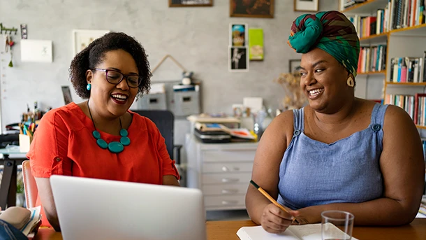 Two women talking at desk