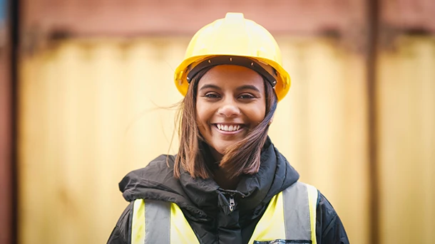 a woman wearing a yellow hard hat and a vest