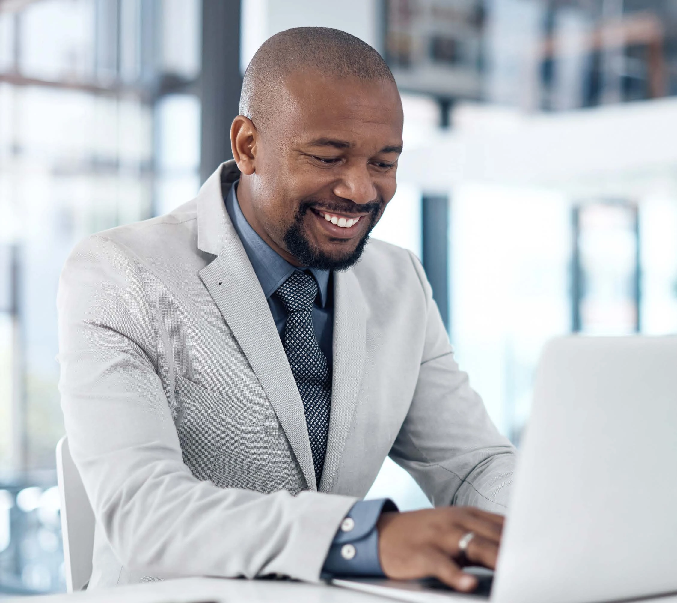 a man in a suit and tie working on a laptop