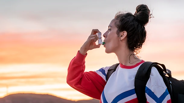 a woman using an asthma inhaler