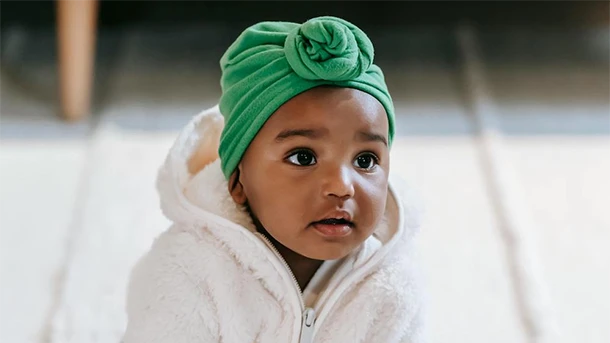 a baby wearing a green hat