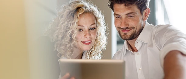 a man and woman looking at a tablet